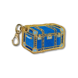 An embroidered charm like a blue treasure chest with gold trim and a gold lobster clasp attached, shown on a plain white background.