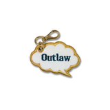 A white cloud-shaped embroidered purse charm with a gold border and the word 'Outlaw' in dark blue text, attached to a gold metal clasp on a white background.