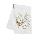 A white kitchen tea towel featuring a watercolor illustration of a pheasant bird surrounded by autumn foliage and the words 'give thanks' in orange script, shown on a plain white background.