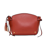 A terracotta red MONTEMARE Roma leather crossbody bag with a drawstring tassel and gold-tone hardware, shown against a plain white background.