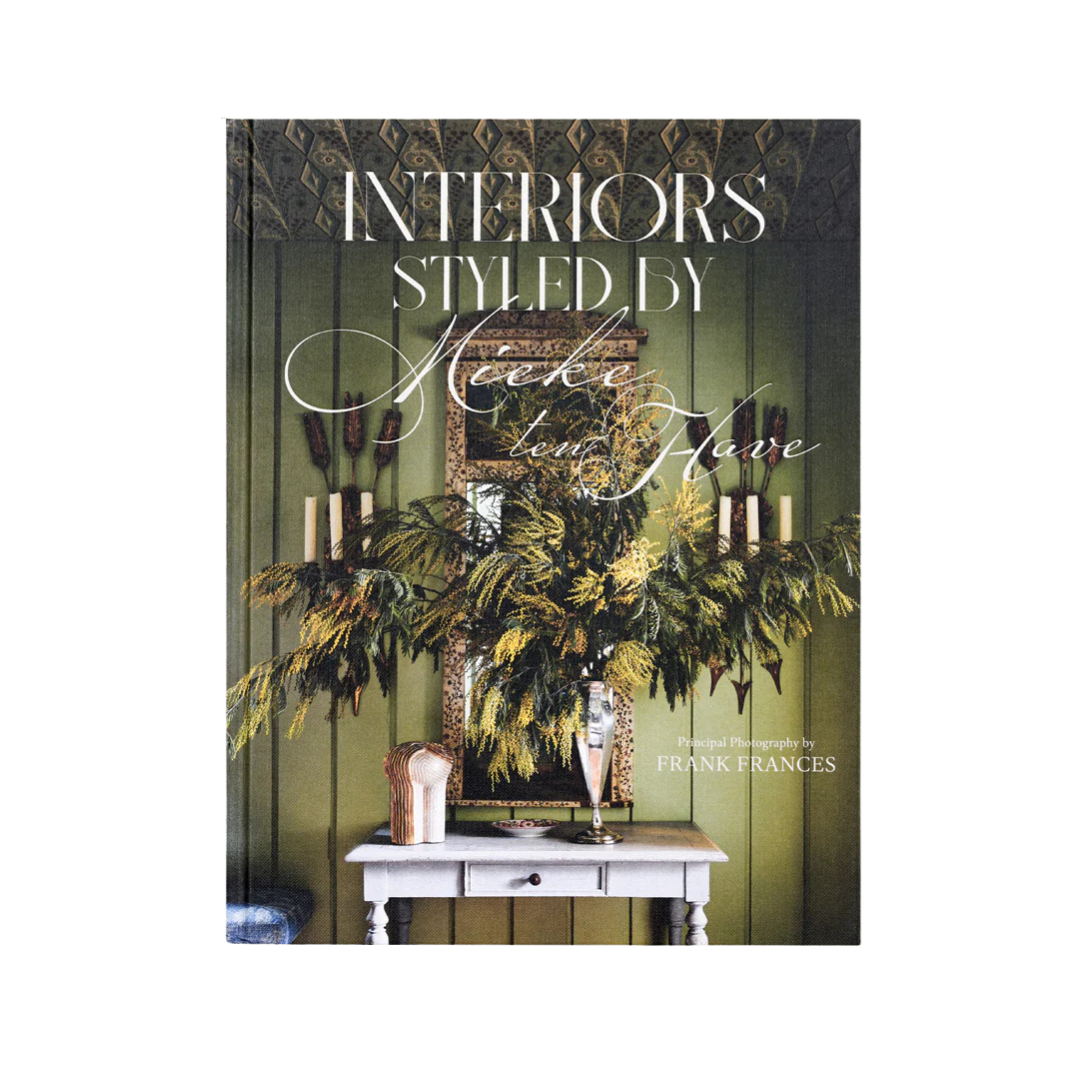 Book cover of 'Interiors Styled by Neeke Low Flave' with decorative elements on a green background.