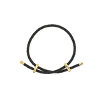 A black braided cord bracelet with polished gold-toned metal end caps and two small gold-toned accent rings, shown on a plain white background.