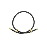 A black braided cord bracelet with polished gold-toned metal end caps and two small gold-toned accent rings, shown on a plain white background.