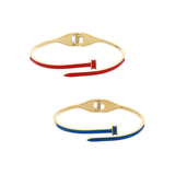 Two slim bangle bracelets with gold-tone metal and colored enamel bands, shown on a plain white background. The top bracelet has a red band, and the bottom bracelet has a blue band.