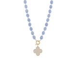 A beaded necklace featuring light blue oval beads and a gold-tone clasp with a white clover-shaped pendant, shown against a plain white background.