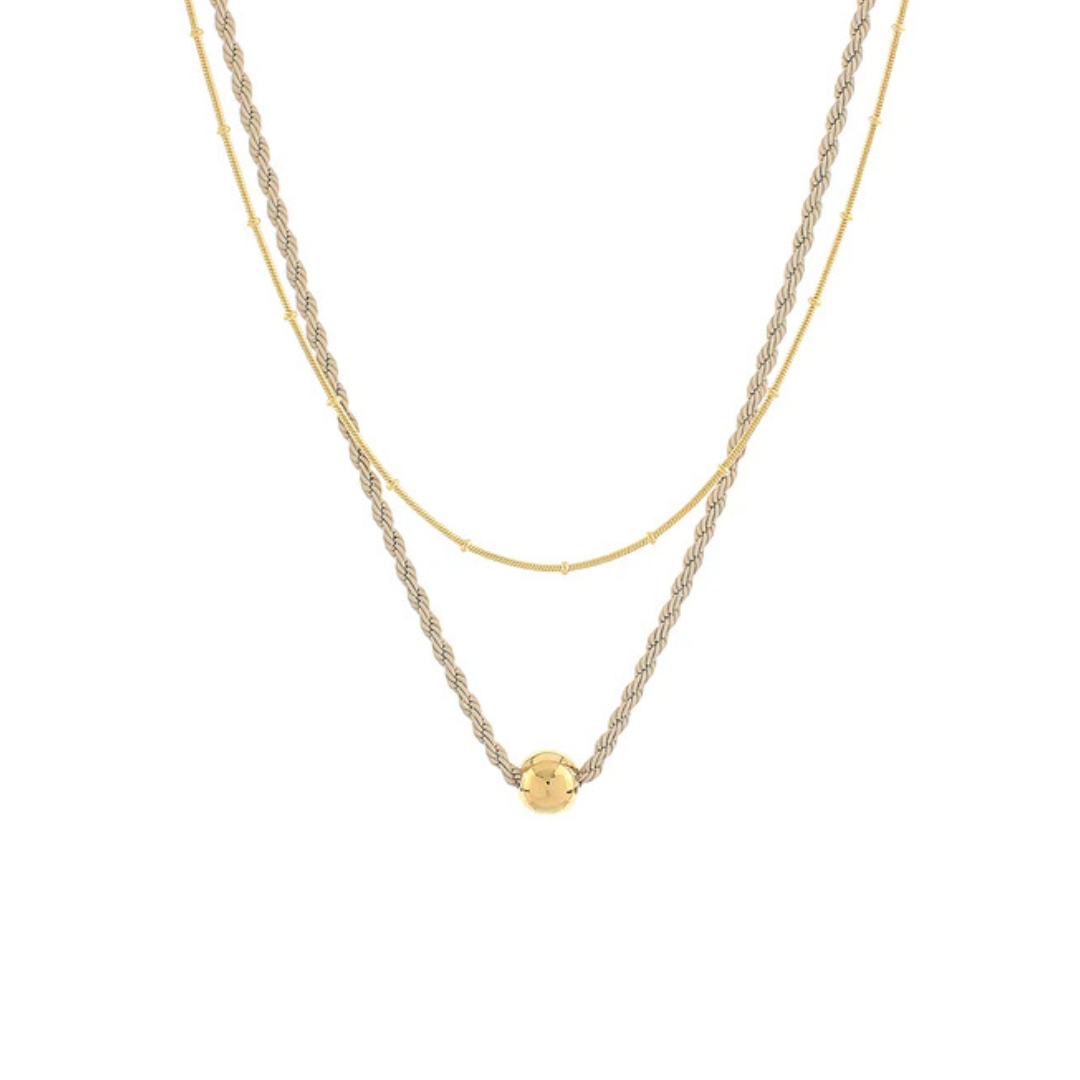 A double-layered gold necklace featuring a textured twisted chain and a delicate fine chain with a small round gold bead pendant, shown against a plain white background.