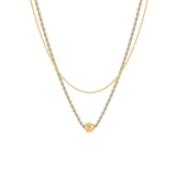 A double-layered gold necklace featuring a textured twisted chain and a delicate fine chain with a small round gold bead pendant, shown against a plain white background.