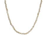 A delicate beaded necklace featuring small, round, pale cream-colored beads separated by tiny gold spacer rings, displayed against a solid white background.