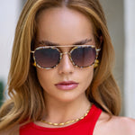 Woman wearing sunglasses with a neutral background