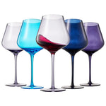 Set of five wine glasses with blue, purple, and red hues on a white background