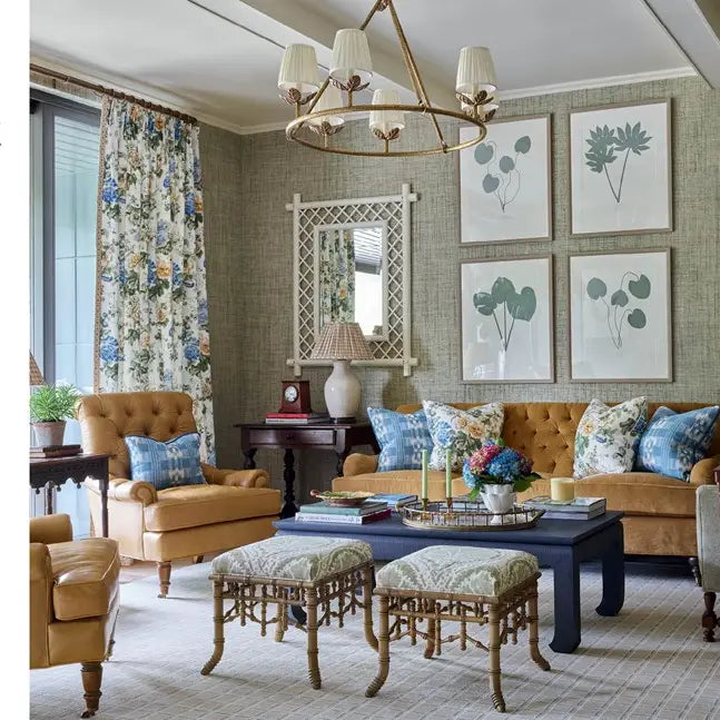 Living room with brown sofa, armchair, and ottomans with decorative pillows.
