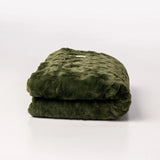 Folded green blanket on a white background