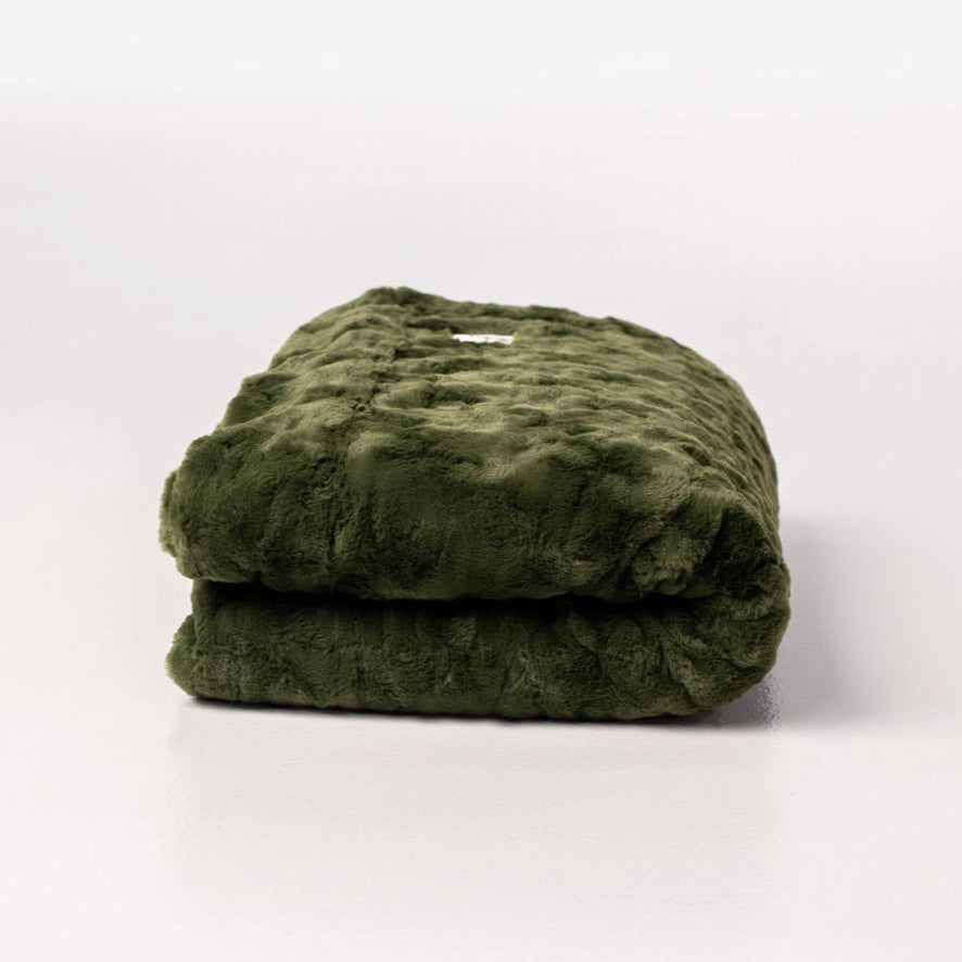 Folded green blanket on a white background