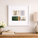 Framed artwork with vintage golf-themed matches on a wall above a wooden console table.