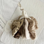 Set of beige and brown scrunchies on a white background