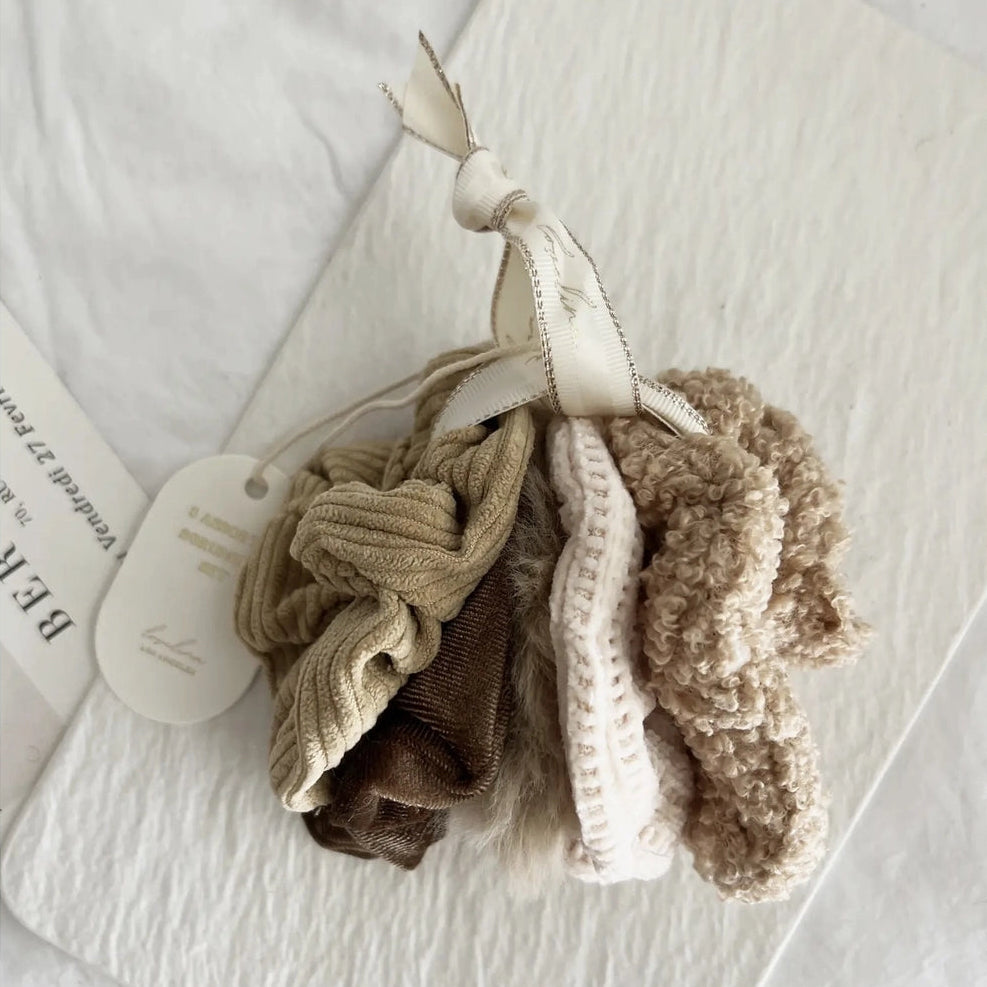 Set of beige and brown scrunchies on a white background