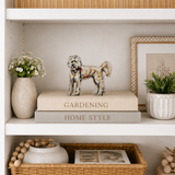 Decorative shelf with books, a dog figurine, and plants.