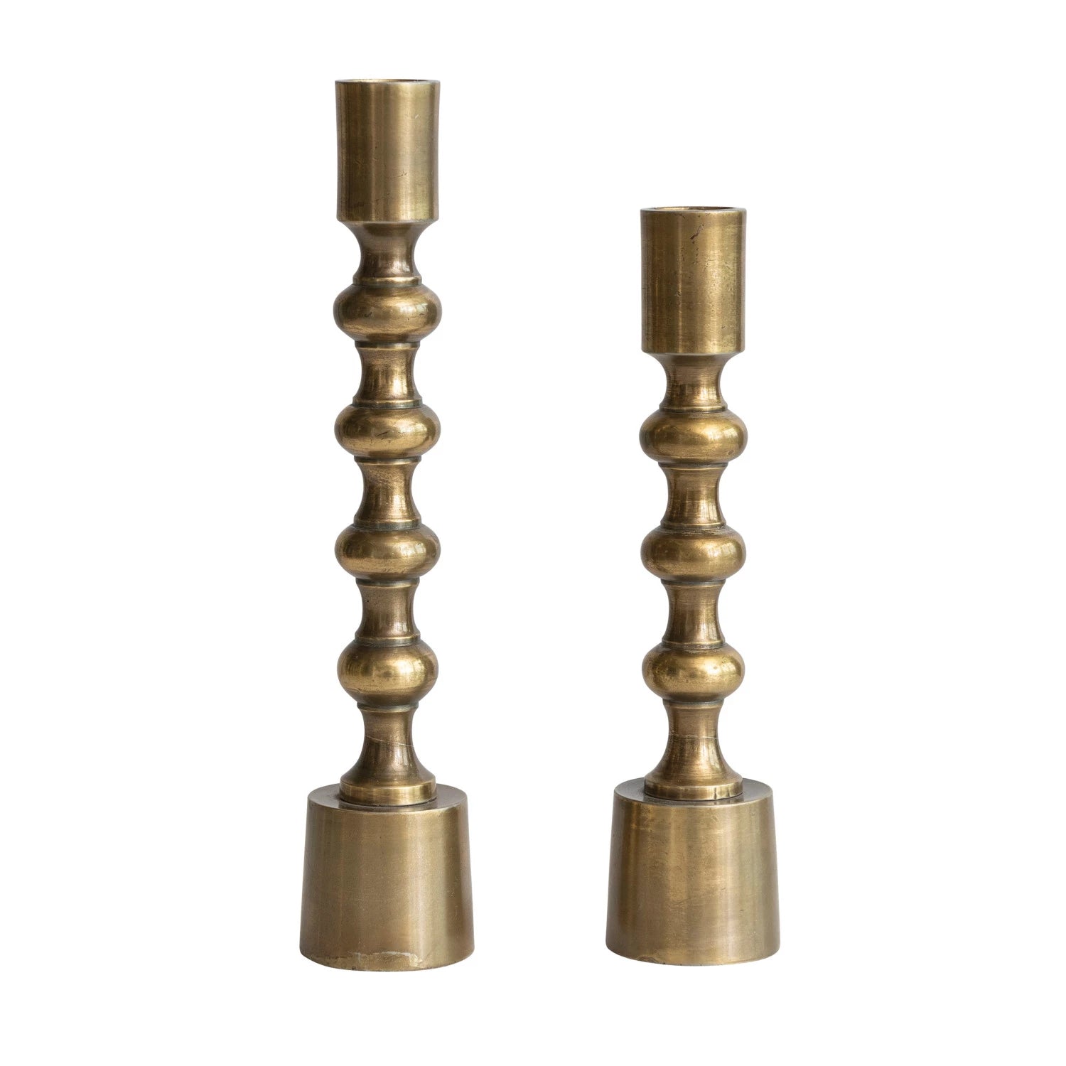 Set of two antique gold taper candle holders in different heights with sculptural bobbin-style detailing.