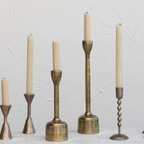 Set of five candle holders with candles on a light gray background