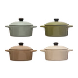 Four ceramic cookware pots with lids in different colors on a white background