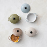 Collection of colorful ceramic cookware on a light surface