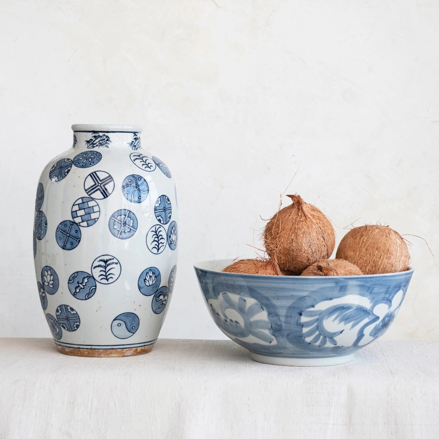 Ceramic vase and bowl with blue patterns on a white surface