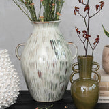 styled hand-painted stoneware vase with twin handles and a reactive glaze of cream, green, and brown styled with other vases