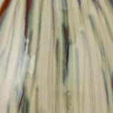 close up view of the reactive glaze of green, brown, and cream on the Miles Vase