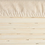 Close-up of a textured beige fabric and wooden surface