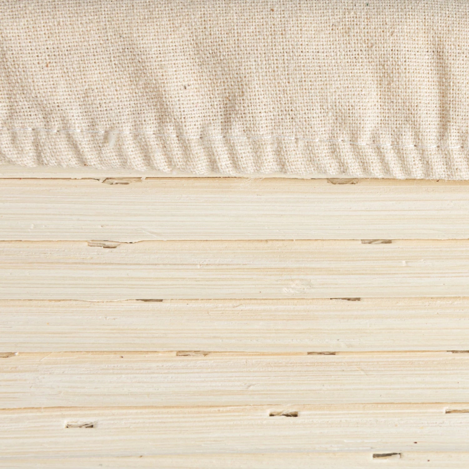 Close-up of a textured beige fabric and wooden surface