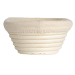 Round bread proofing basket made of woven rattan on a white background