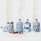 Set of four blue and white ceramic canisters with decorative patterns on a white background