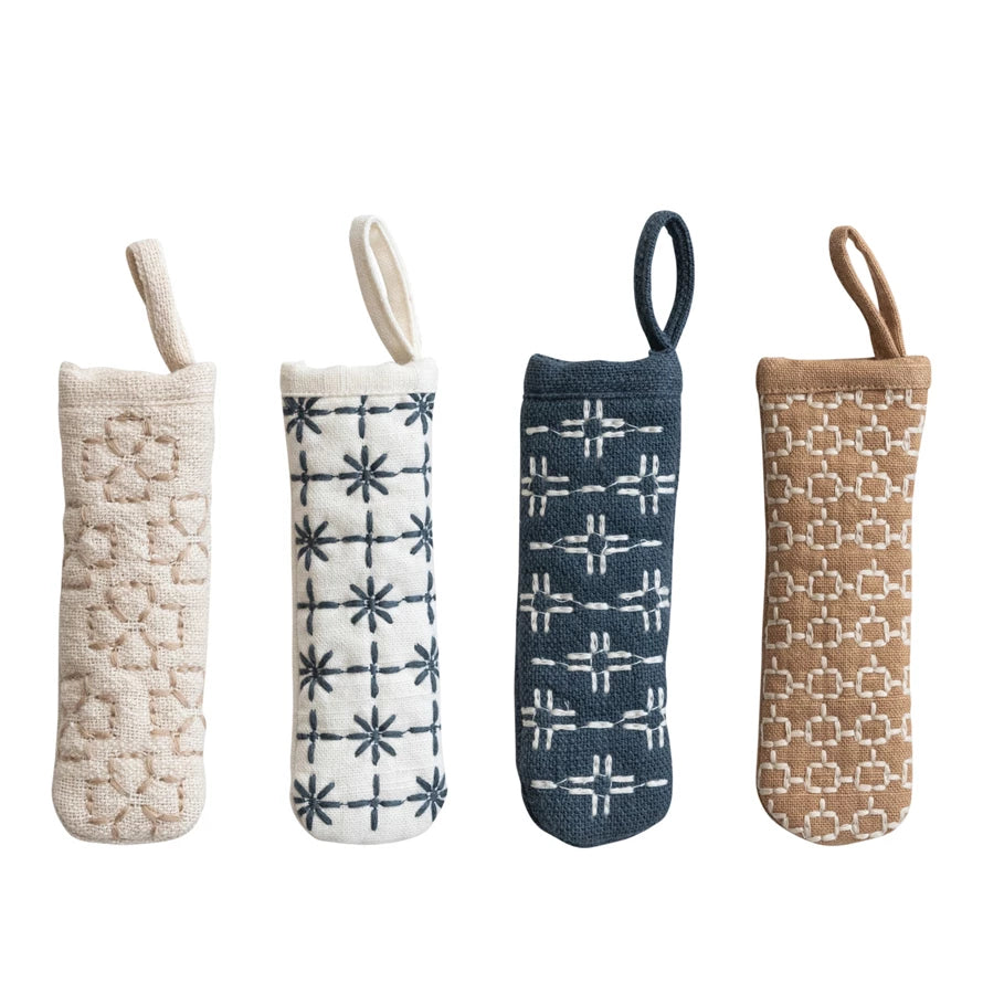Four textured fabric pot handle covers with different patterns on a white background