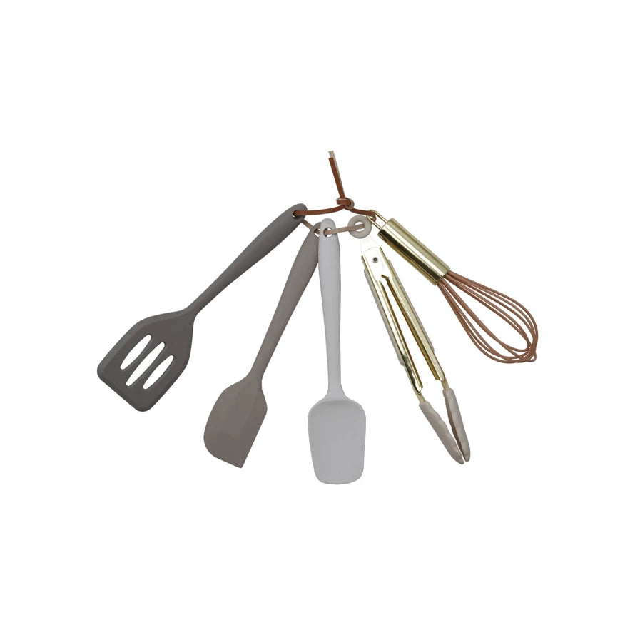 Set of kitchen utensils including a spatula, ladle, and whisk on a white background