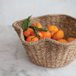 Woven basket with oranges on a marble surface