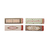 Four matchboxes with decorative labels on a white background