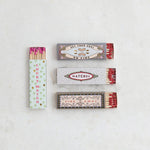 Four matchboxes with colorful labels on a light gray background