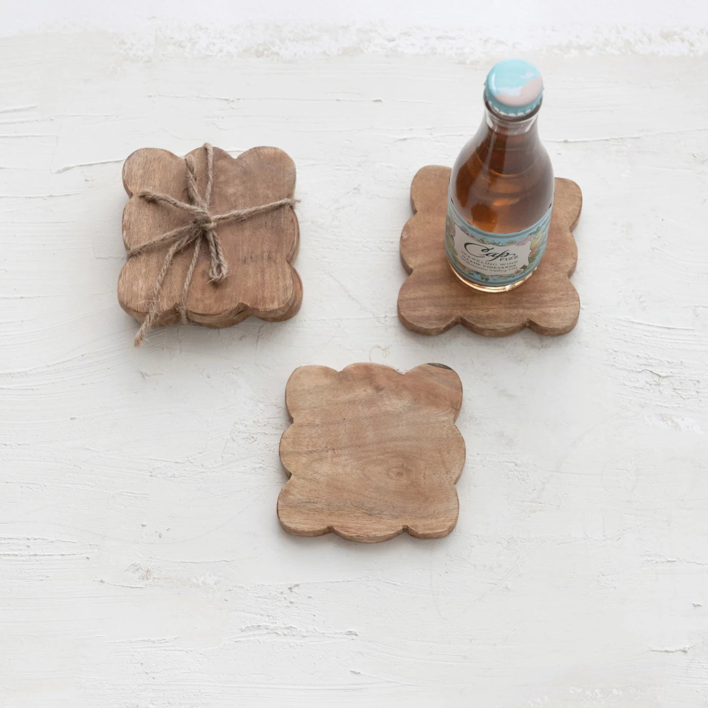 styled set of four mango wood coasters tied together with a jute rope