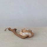 Wooden bread knife with a loaf of bread on a light surface