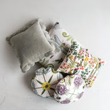 Set of decorative pillows with floral patterns on a light gray background