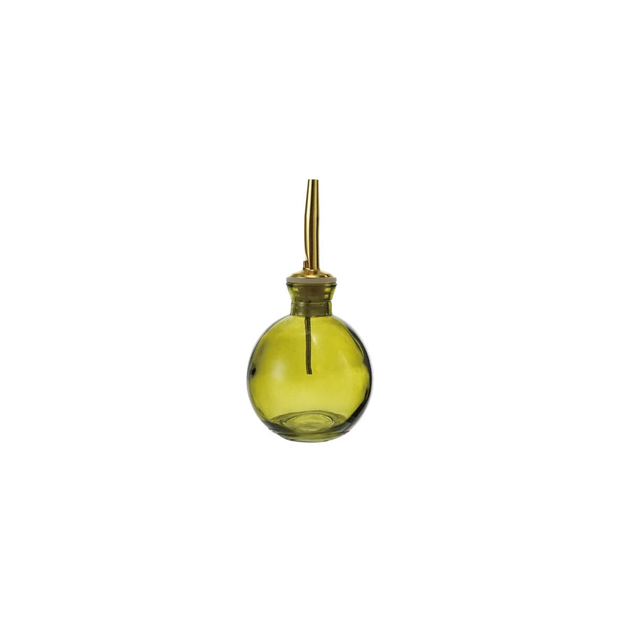 Green glass bottle with brass cap on a white background