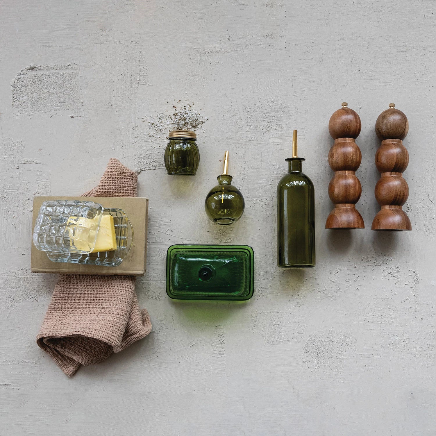 Collection of kitchen items including bottles and a towel on a textured wall.