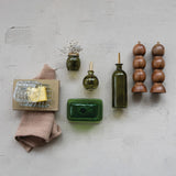Collection of kitchen items including bottles and a towel on a textured wall.