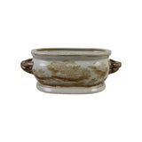 An oval ceramic planter pot with side handles, featuring a cream-colored glaze with brown landscape-style floral patterns and a matching base.
