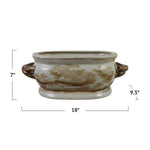 An oval ceramic planter with a brown and beige toile-style landscape pattern on a cream background, shown with dimension lines indicating 7 inches height, 18 inches width, and 9.5 inches depth.