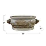 An oval ceramic planter with a brown and beige toile-style landscape pattern on a cream background, shown with dimension lines indicating 7 inches height, 18 inches width, and 9.5 inches depth.