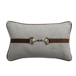 Gray pillow with a brown leather belt and metallic buckle on a white background
