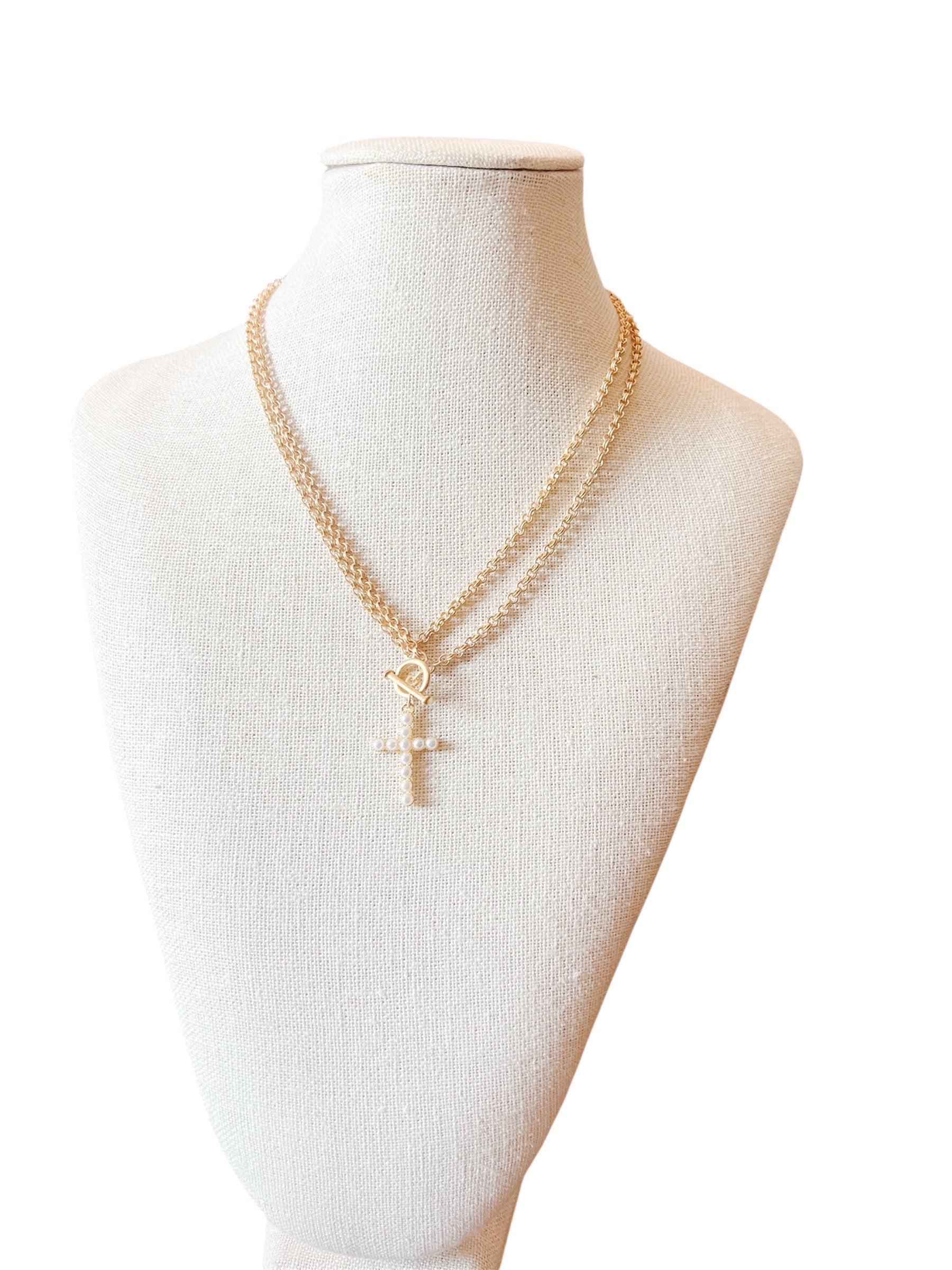  Necklace blends elegance with modern edge, featuring a double-layered gold chain and a sleek toggle clasp. A white pearl cross charm 