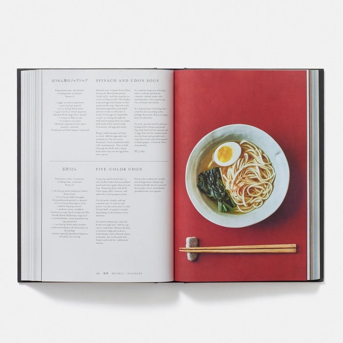 Open book with a page showing a recipe for a dish with noodles and an egg, and another page with text.