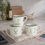 Three white mugs with green designs on a kitchen counter